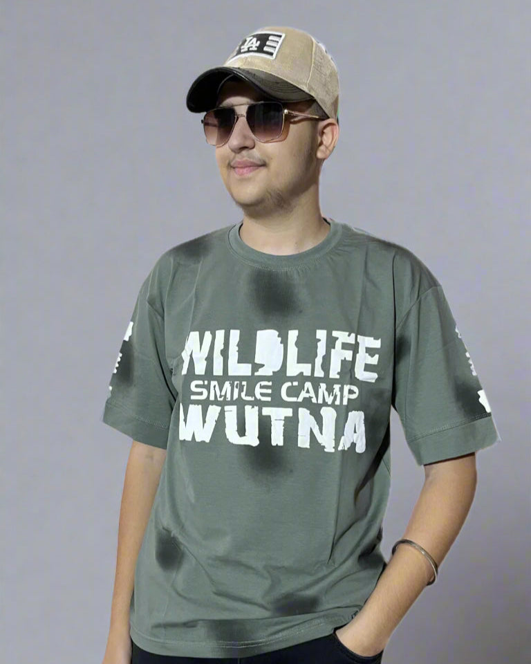 Person wearing a gray t-shirt with text and a cap on a white background