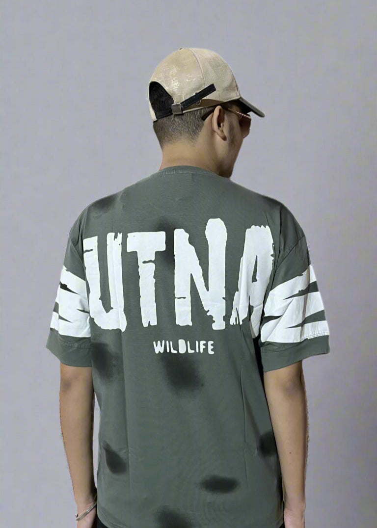 Person wearing a green t-shirt with 'UTNA' branding on the back, standing against a white background.