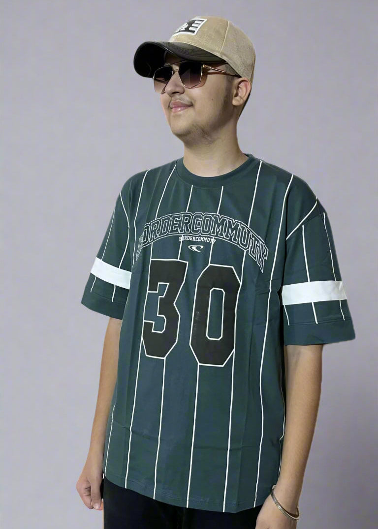 Person wearing a green sports jersey with number 30 and a cap on a gray background