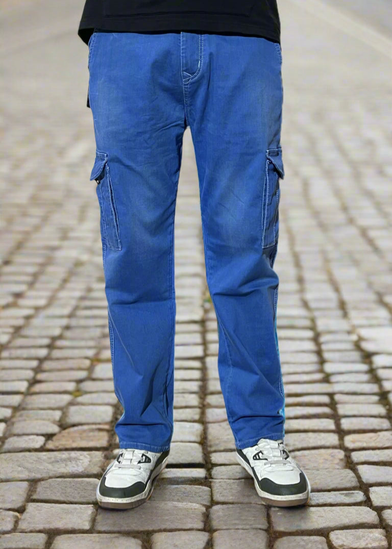 Blue cargo pants worn over a black top on a white background